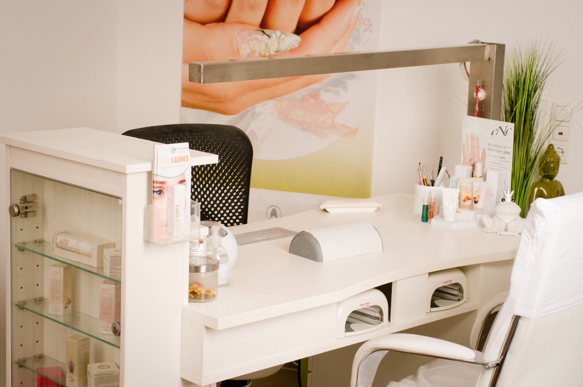 Maniküre-Arbeitsplatz mit Nageltisch und Pflegeprodukten